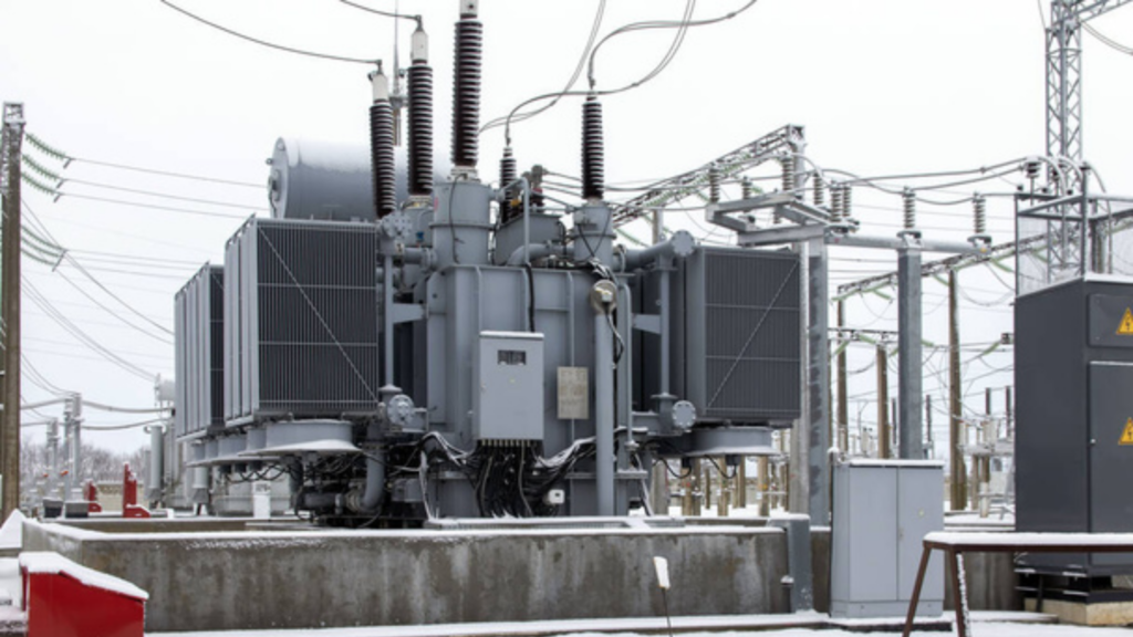 A power transformer is in less than ideal conditions, covered in snow